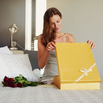 Ooh, I love it. a young woman opening a surprise gift at home