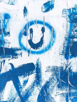 Abstract graffiti smile. Blue brush strokes on the white wall. Buskers.