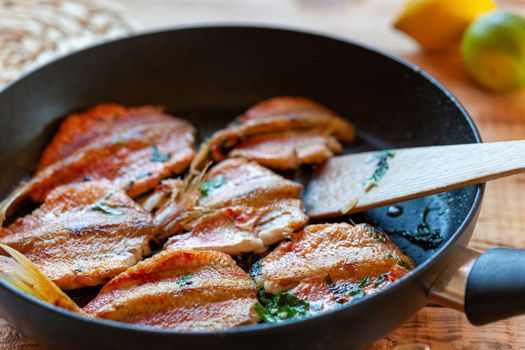 red mullet fish cooked on a pan, side view, selective focus
