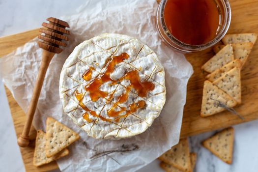 camembert soft french cheese served with liquid honey and crackers, top view
