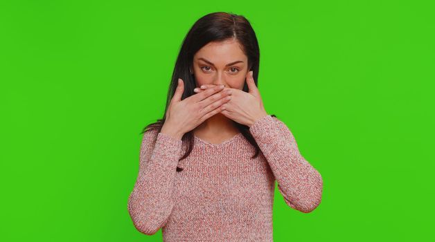 I will not say anyone. Frightened woman closing mouth with hands, looking intimidated scared at camera, gestures no, refusing to tell terrible secret, unbelievable truth. Girl on chroma key background