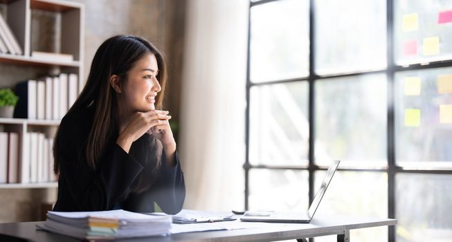 Business woman using calculator for do math finance on wooden desk in office and business working background, tax, accounting, statistics and analytic research concept...