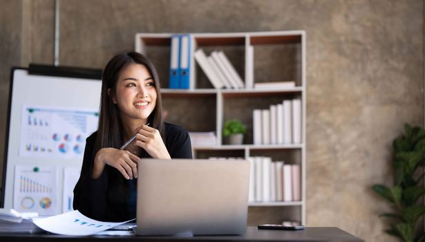 Business woman using calculator for do math finance on wooden desk in office and business working background, tax, accounting, statistics and analytic research concept...