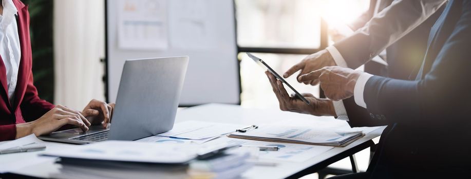 Business People Meeting using laptop computer,calculator,notebook,stock market chart paper for analysis Plans to improve quality next month. Conference Discussion Corporate Concept....