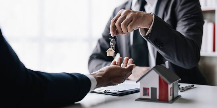 Real estate agents agree to buy a home and give keys to clients at their agency's offices. Concept agreement..