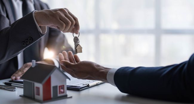 Real estate agents agree to buy a home and give keys to clients at their agency's offices. Concept agreement..