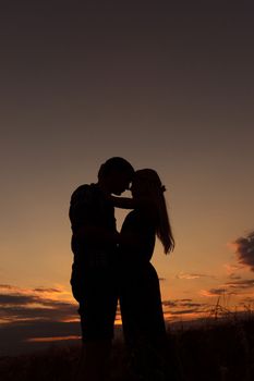 couple in love blonde girl in silhouette against an orange sunset