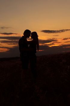 couple in love blonde girl in silhouette against an orange sunset