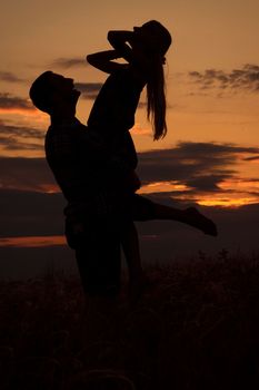 couple in love blonde girl in silhouette against an orange sunset