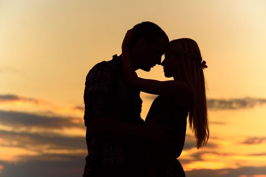 couple in love blonde girl in silhouette against an orange sunset