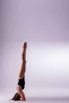 Portrait of a beautiful young woman wearing black sportswear working out in studio. Full length.