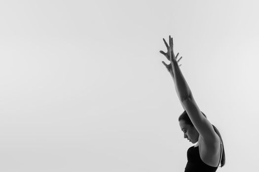 Portrait of a beautiful young woman wearing black sportswear working out in studio. Full length.