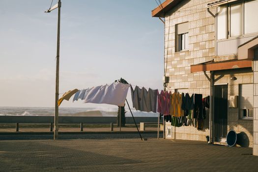 Street clothesline on against blue sky and wavy coast.