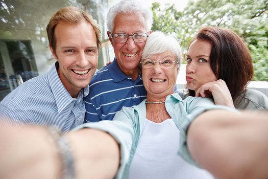 Family is as family does. four adults taking a family selfie
