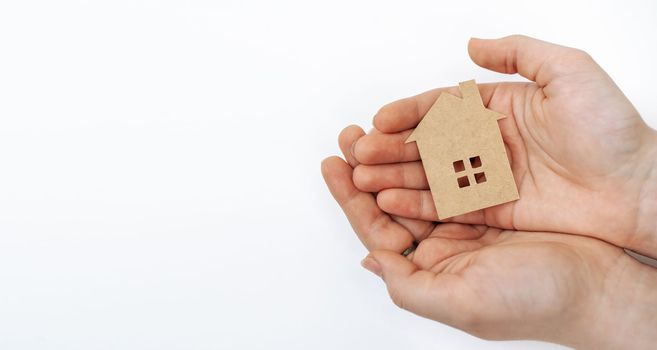 hands holding paper house, family home, homeless housing, mortgage crisis and home protecting insurance concept, foster home care, family day care, social distancing.