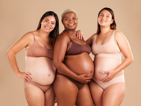 Portrait, beauty and tummy with pregnant friends in studio on a beige background for diversity or motherhood. Family, love and pregnancy with a woman friend group showing their baby bump stomach.