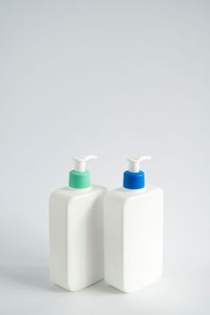 White blank plastic bottles with dispenser pump for gel, liquid soap, lotion, cream, shampoo on white background. Cosmetics