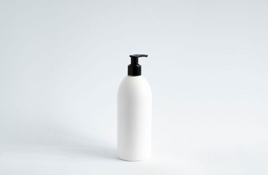 White blank plastic bottle with black dispenser pump for gel, liquid soap, lotion, cream, shampoo on white background. Cosmetics