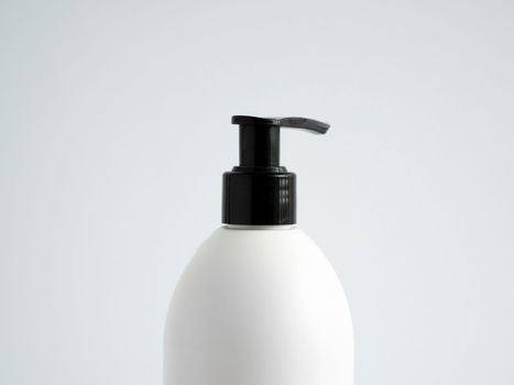 Close up white blank plastic bottle with black dispenser pump for gel, liquid soap, lotion, cream, shampoo on white background. Cosmetics