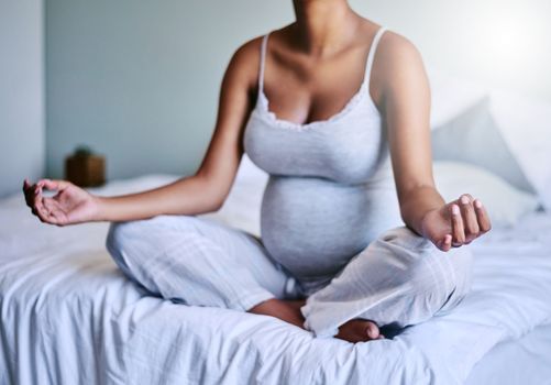 Yoga helps you to connect more with your baby. a pregnant woman doing yoga in her bedroom