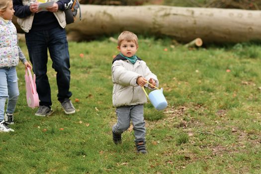Boy collects the eggs in a basket Easter