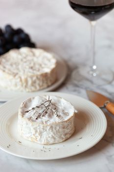 camembert french soft cheese served with red wine and grapes, side view