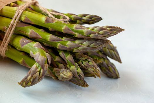 bunch of fresh organic.asparagus diagonal on the light blue background, top view
