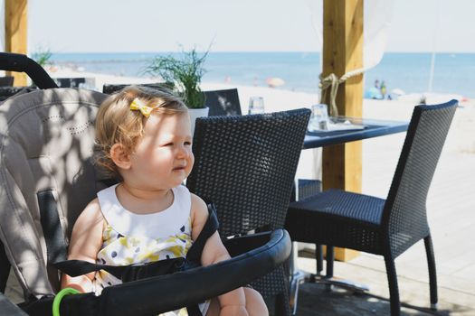 Girl child in a stroller in a restaurant