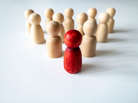 Red wooden doll leading the rest of wooden figure. Leadership and followers concept. Copy space