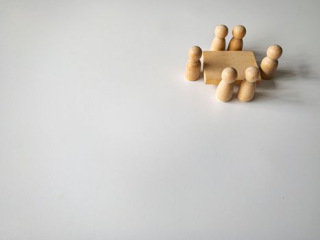 Wooden people figures having business meeting with customizable space for text. Meeting concept and copy space.