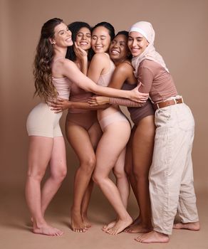 Diversity hug, beauty and body positive women in studio on a brown background. Underwear, skincare and group of different, young or happy female models in makeup with eyes closed posing for self love.