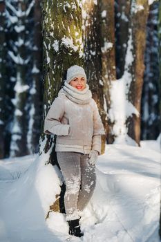 Portrait of a woman in gray clothes in a winter forest.Girl in the new year's snow-covered forest