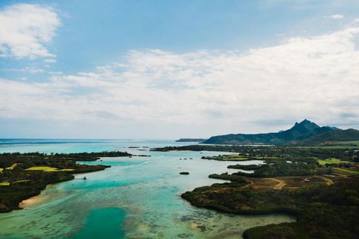 Aerial picture of the east coast of Mauritius Island. Beautiful lagoon of Mauritius Island shot from above. Boat sailing in turquoise lagoon.