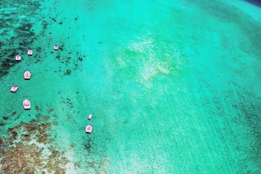 Aerial picture of the east coast of Mauritius Island. Beautiful lagoon of Mauritius Island shot from above. Boat sailing in turquoise lagoon.