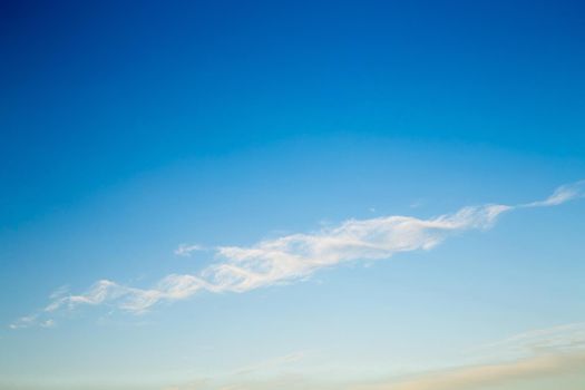 Beautiful blue sky with a white cloud in the form of a DNA helix. Sky panorama for screensavers, postcards, calendar, presentations. Warm summer day.