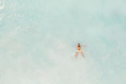 The view from the bird's eye view of the ocean, filled with people on a hot Sunny day.People swim in the Indian ocean on the island of Mauritius.