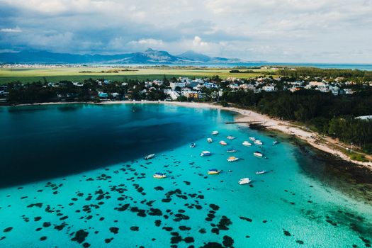 Aerial picture of the east coast of Mauritius Island. Beautiful lagoon of Mauritius Island shot from above. Boat sailing in turquoise lagoon.