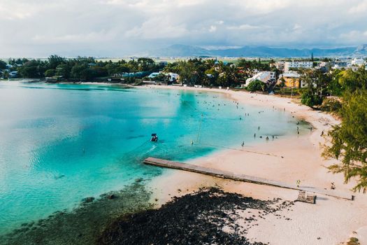 Aerial picture of the east coast of Mauritius Island. Beautiful lagoon of Mauritius Island shot from above. Boat sailing in turquoise lagoon.