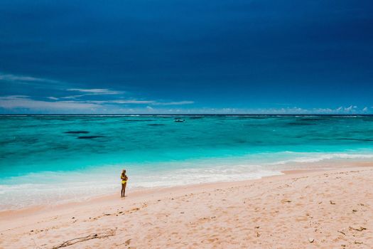 Mauritius, Indian Ocean - portrait of a girl walking along the beach with tourists from all over the world visiting the paradise island of Mauritius