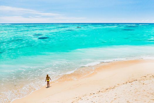 Mauritius, Indian Ocean - portrait of a girl walking along the beach with tourists from all over the world visiting the paradise island of Mauritius