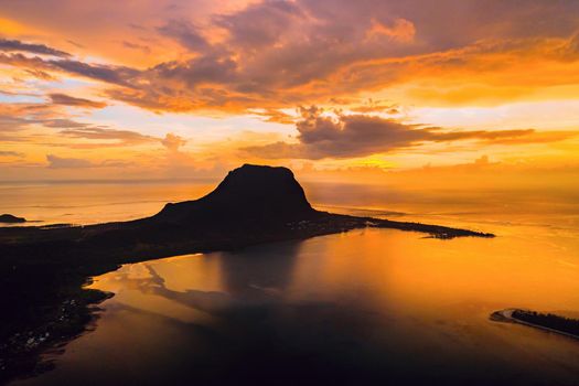 Aerial view with ocean at warm sunset time and Le Morn mountain in Mauritius