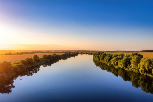 A sunset or sunrise scene over a lake or river with skies reflecting in the water on a summer evening or morning. Landscape.