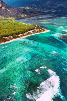 The view from the bird's eye view of the coral reef near the mountain Le Morne Brabant, a beautiful blue lagoon and the underwater waterfall.