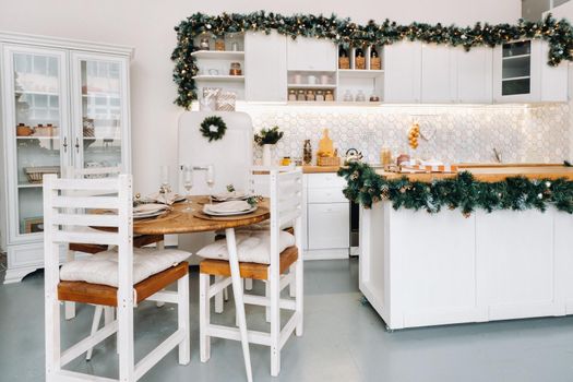 Christmas table decoration in the kitchen, Banquet table with glasses before serving food, close-up of the Christmas dinner table with seasonal decorations, crystal glasses and decorative deer.