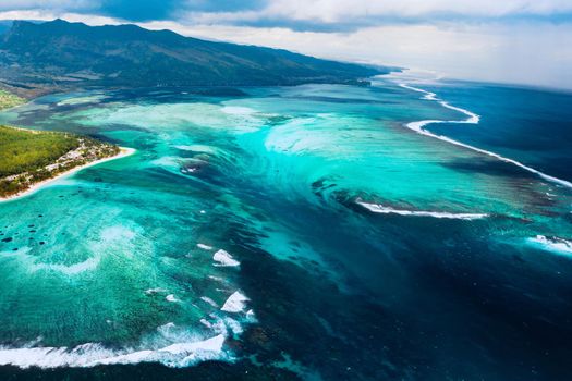 The view from the bird's eye view of the coral reef near the mountain Le Morne Brabant, a beautiful blue lagoon and the underwater waterfall.