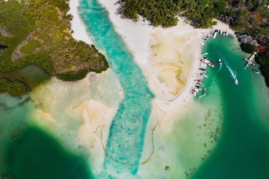 Aerial picture of the east coast of Mauritius Island. Beautiful lagoon of Mauritius Island shot from above. Boat sailing in turquoise lagoon.