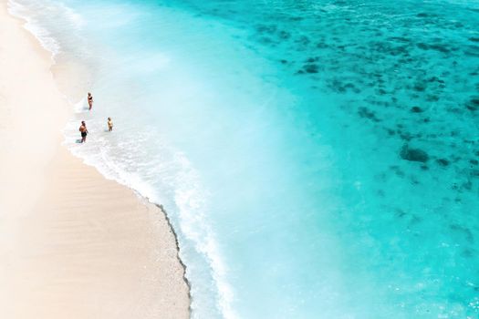 A family stands on Le Morne beach in the Indian Ocean on the island of Mauritius.