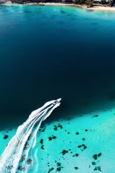 Top view of the Blue Bay lagoon of Mauritius. A boat floats on a turquoise lagoon.