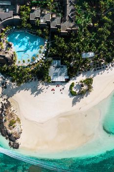 View from the height of the east coast of the island of Mauritius. Flying over the turquoise lagoon of the island of Mauritius in the area of Bel Mare