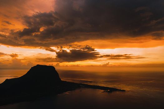 Aerial view with ocean at warm sunset time and Le Morn mountain in Mauritius